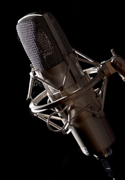 schwarz-graues Studiomikrofon vor schwarzem Hintergrund